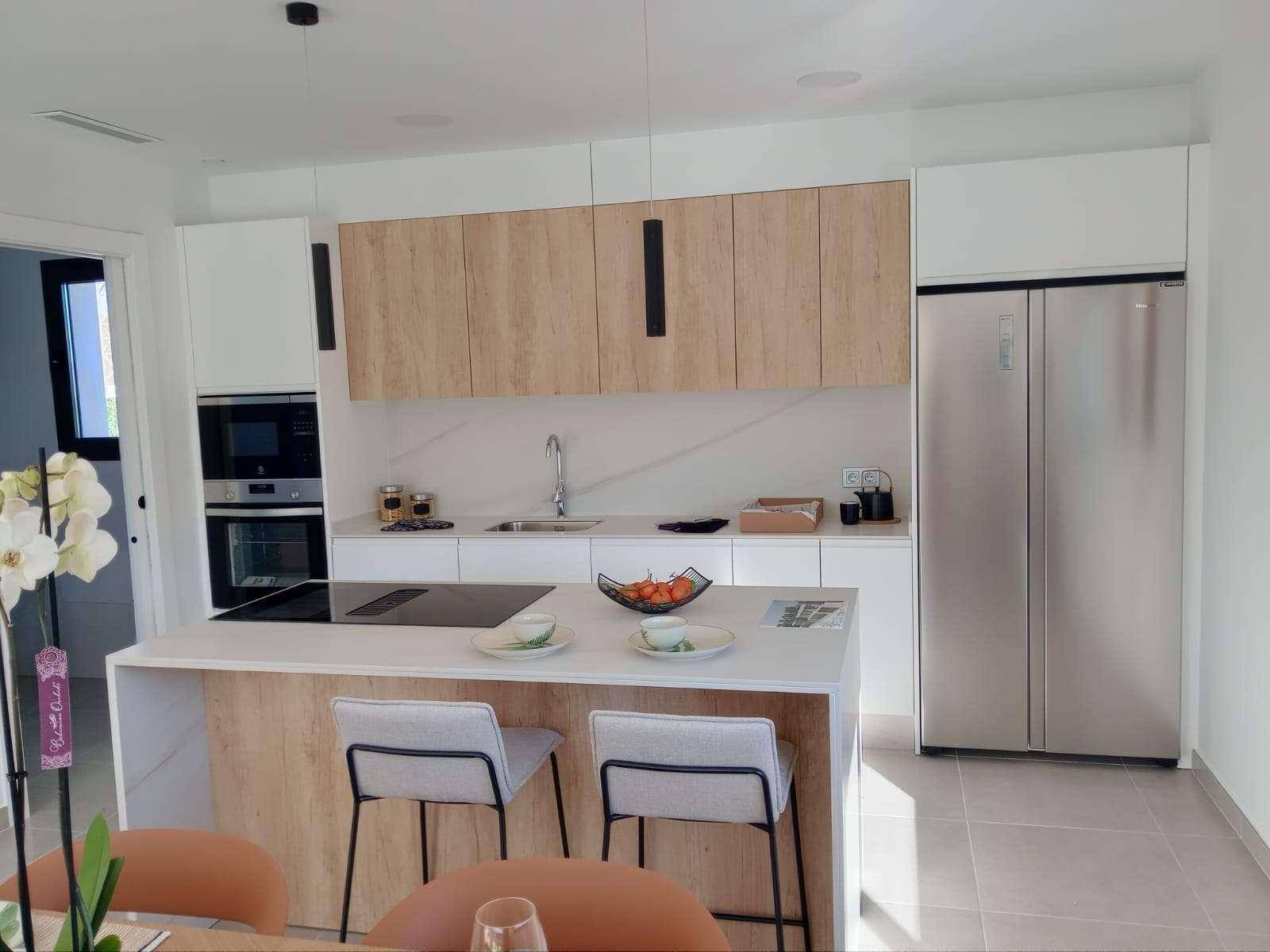 Moderne Küche mit Kochinsel, Induktionskochfeld und großem Kühlschrank.
