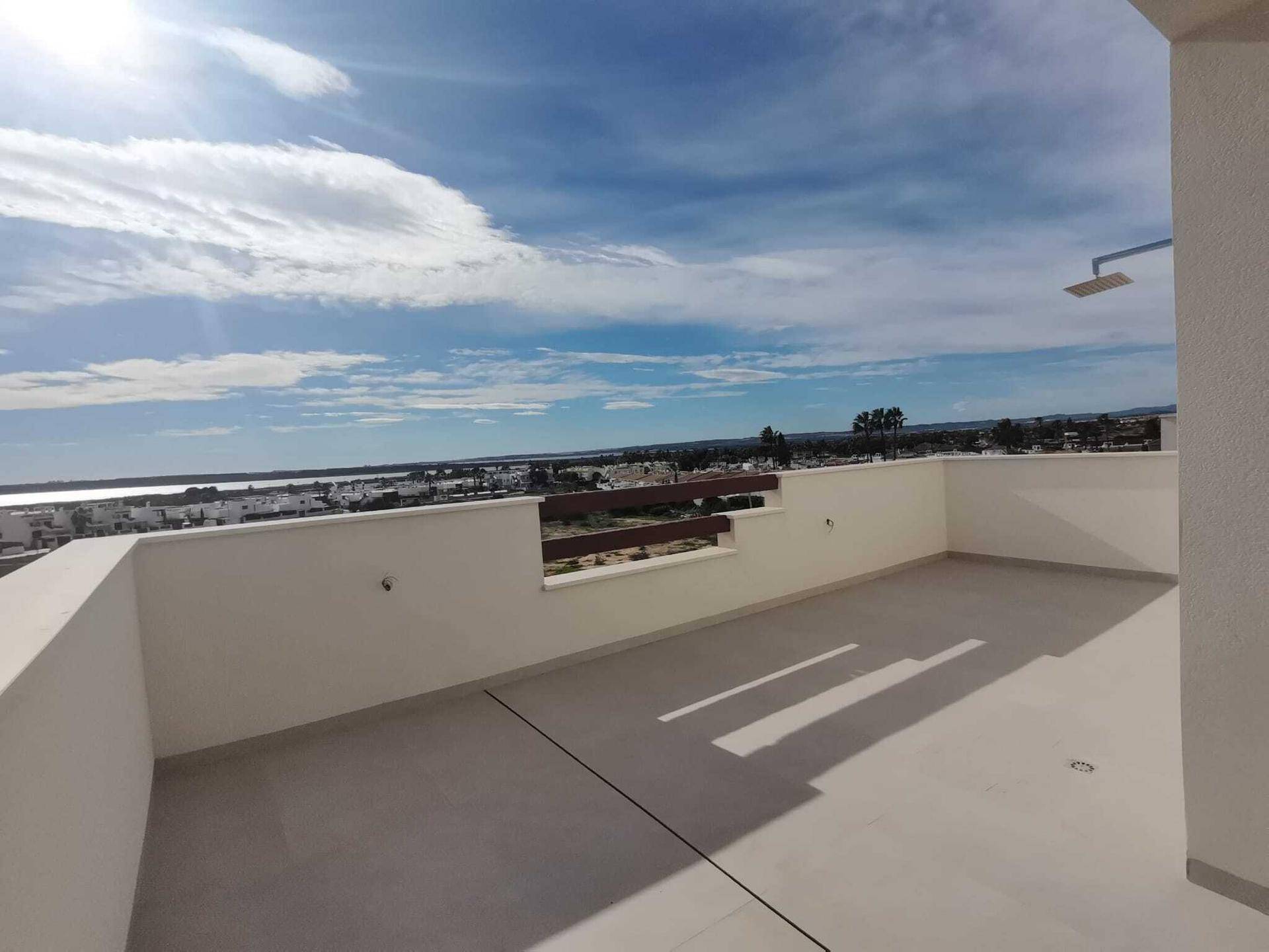 Geräumige Dachterrasse mit Außendusche und weitem Blick auf die Umgebung und das Meer.
