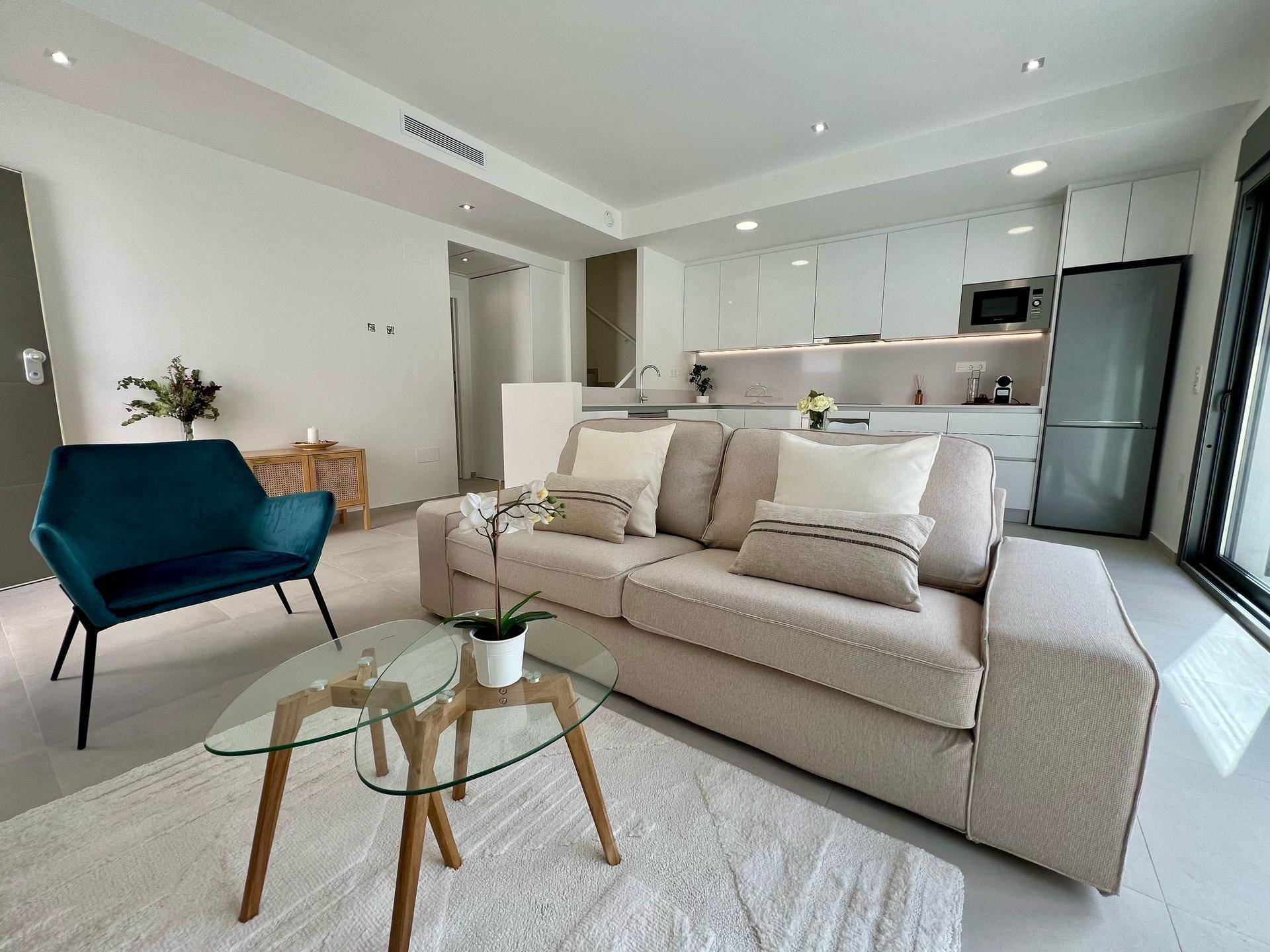 Gemütlicher Wohnbereich mit Sofa und Blick auf die offene Küche in modernem Design.