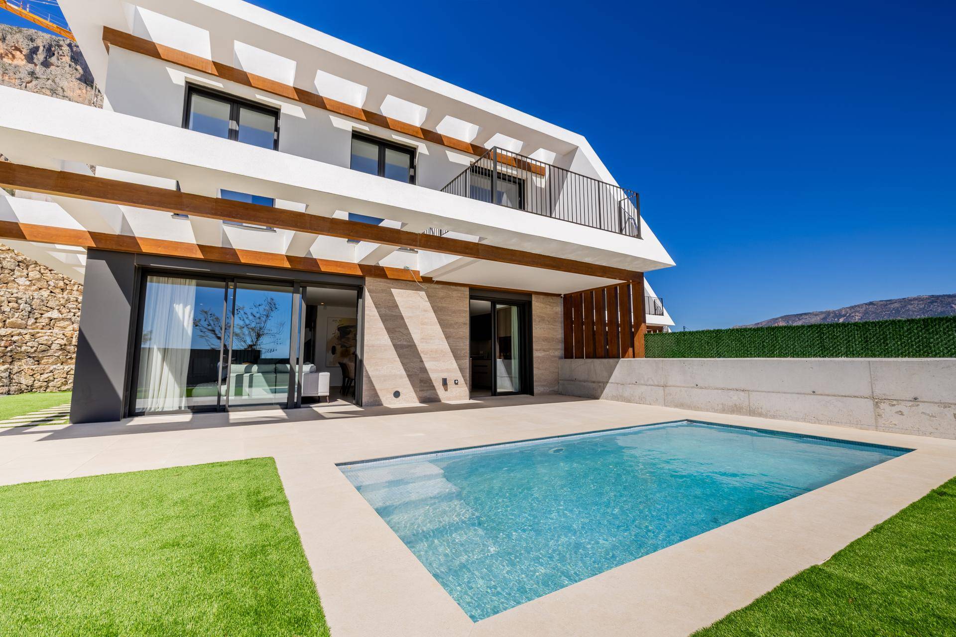 Elegante Villa mit privatem Pool und gepflegtem Kunstrasen, umgeben von einer modernen Architektur.