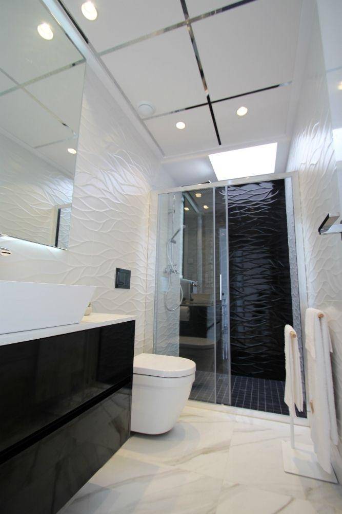 Modernes Badezimmer mit begehbarer Dusche, Wand-WC und stilvollen Wandfliesen.