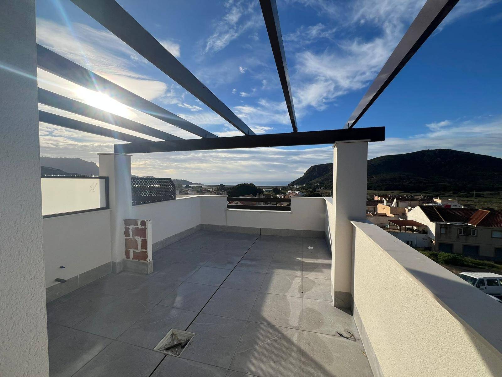 Geräumige Dachterrasse mit Pergola-Struktur und Panoramablick auf die umliegende Landschaft.