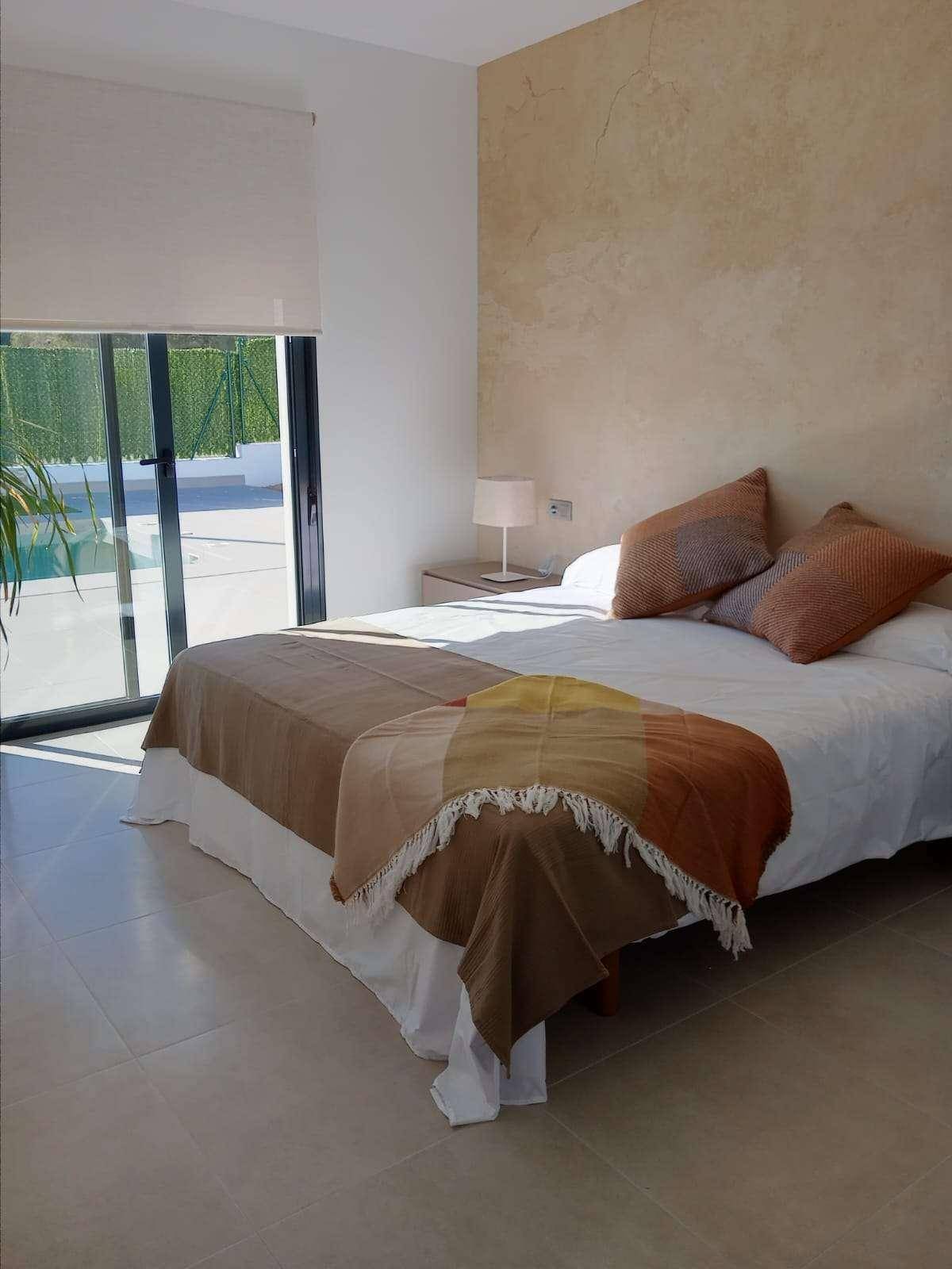 Gemütliches Schlafzimmer mit Akzentwand und direktem Zugang zum Poolbereich.