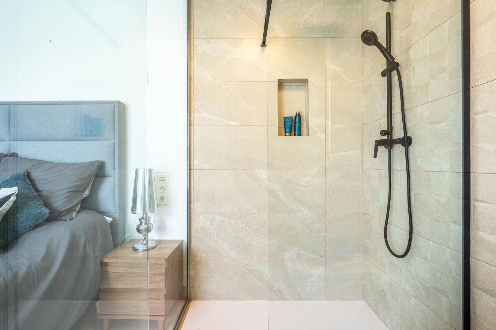 Moderne begehbare Dusche mit großformatigen Fliesen und minimalistischem Design.