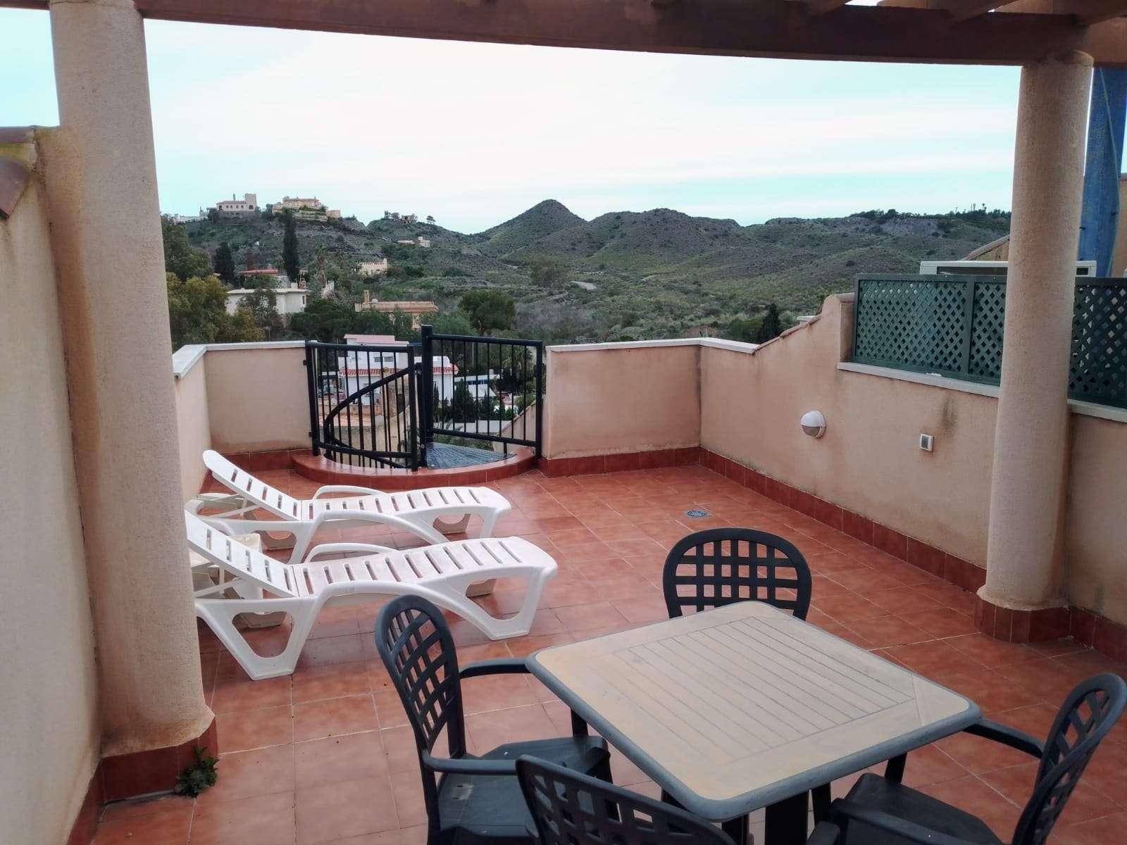 Geräumige Dachterrasse mit Liegestühlen und Esstisch, bietet weite Aussicht auf die Landschaft.