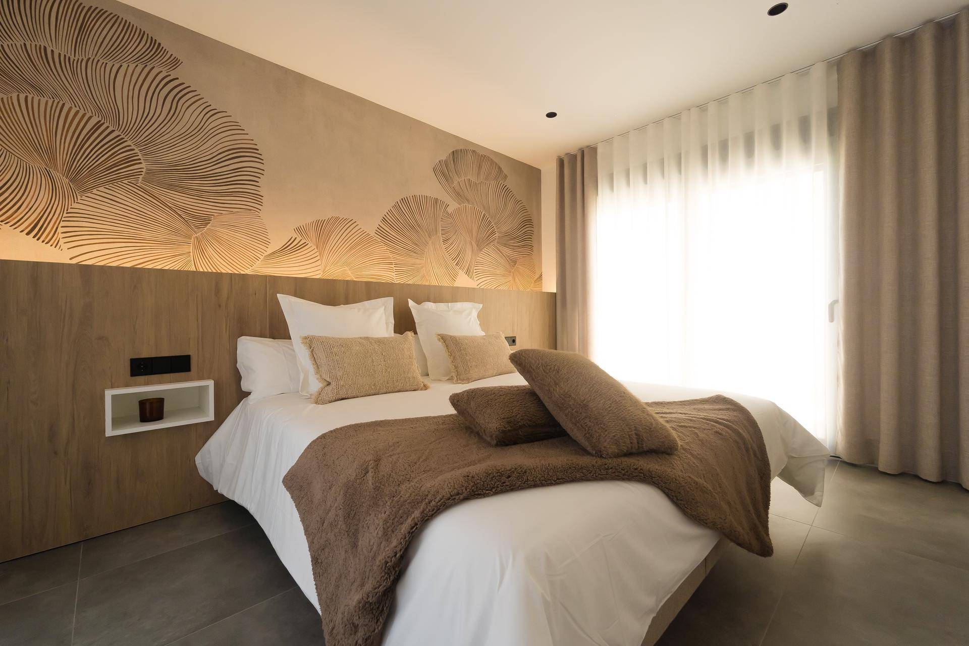 Stilvolles Schlafzimmer mit Doppelbett, Holzkopfteil und dekorativer Wandgestaltung.