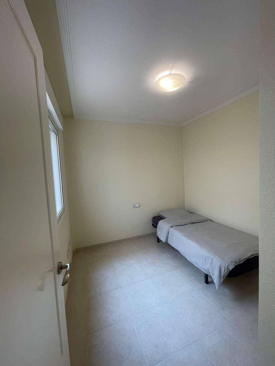 Kleines Schlafzimmer mit Einzelbett und Fliesenboden, ideal als Gäste- oder Kinderzimmer.