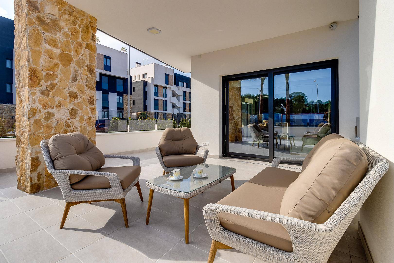 Geräumige Terrasse mit modernen Sitzgelegenheiten und Zugang zum Innenbereich durch Glasschiebetüren.