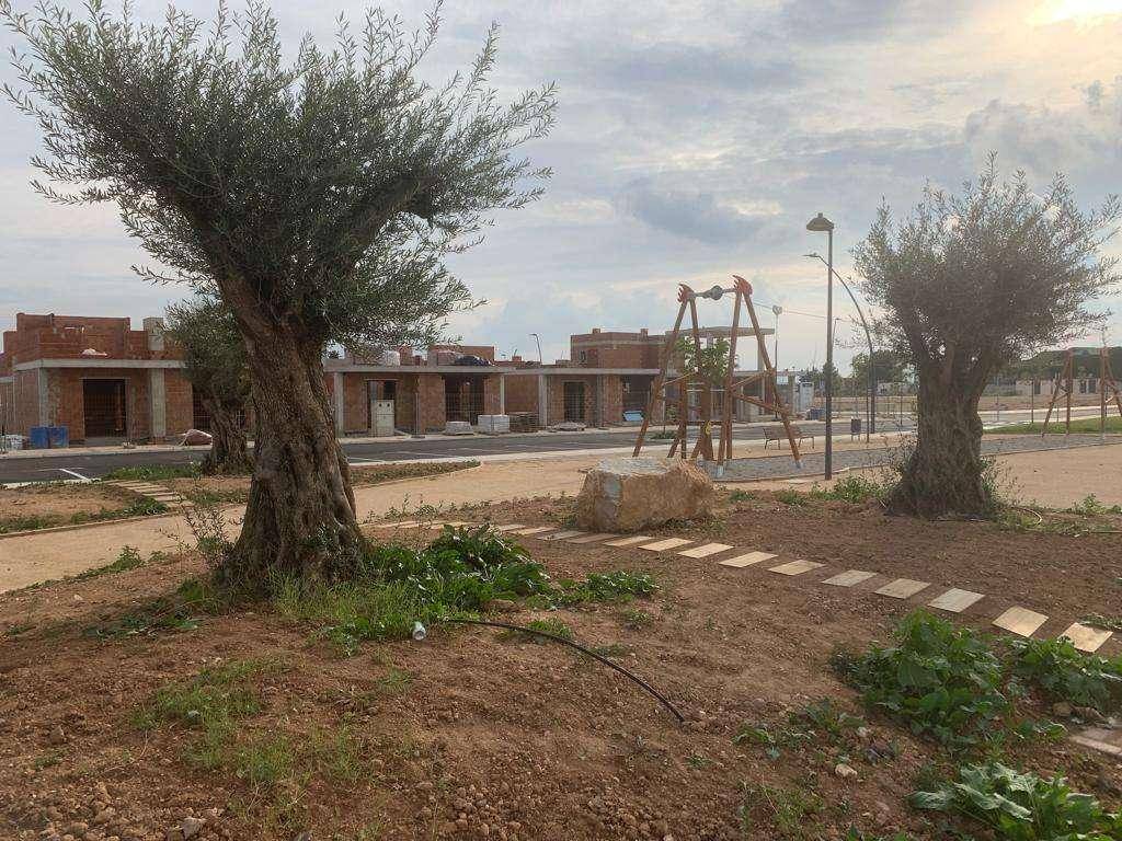 Spielplatz in einer neuen Wohnsiedlung mit im Bau befindlichen Häusern im Hintergrund.