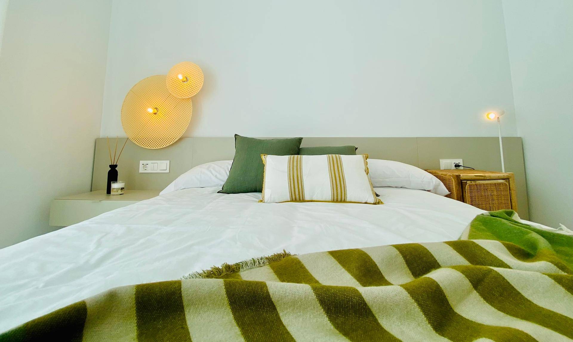 Modernes Schlafzimmer mit Doppelbett, minimalistischer Dekoration und indirekter Beleuchtung.