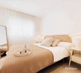 Helles Schlafzimmer mit modernem Bett, Nachttisch und großem Standspiegel.