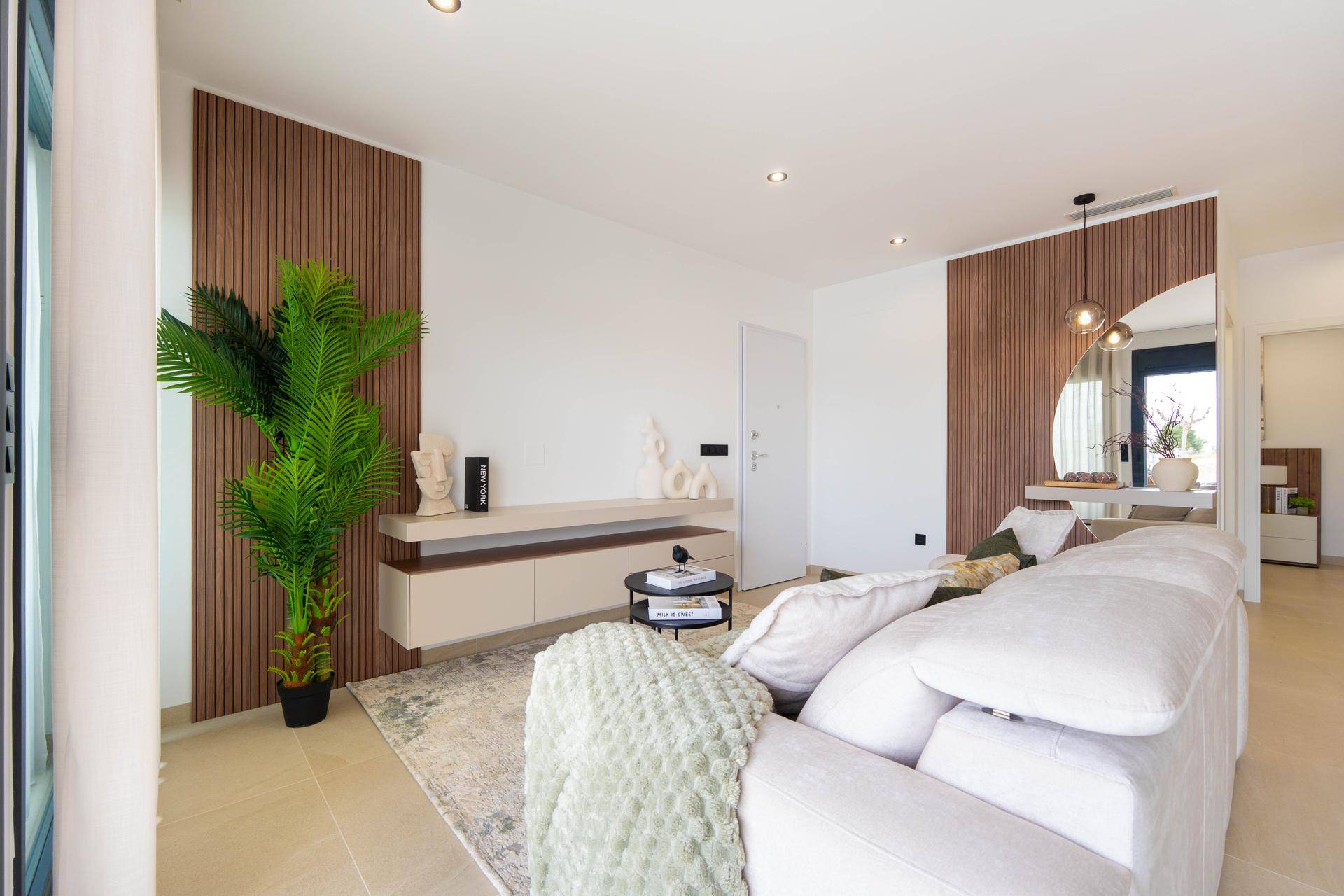 Geräumiger Wohnbereich mit beigem Sofa, Holzwandakzenten und moderner Einrichtung.