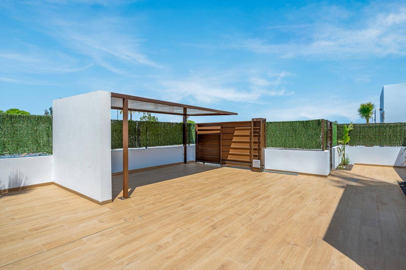 Geräumige Dachterrasse mit Pergola und Sichtschutz, ideal für Entspannung im Freien.