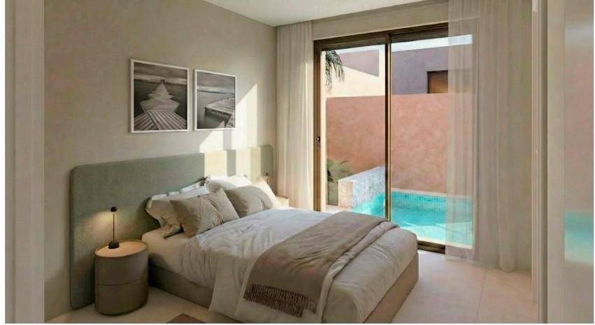 Helles Schlafzimmer mit Doppelbett, Nachttisch und direktem Zugang zu einem privaten Pool.