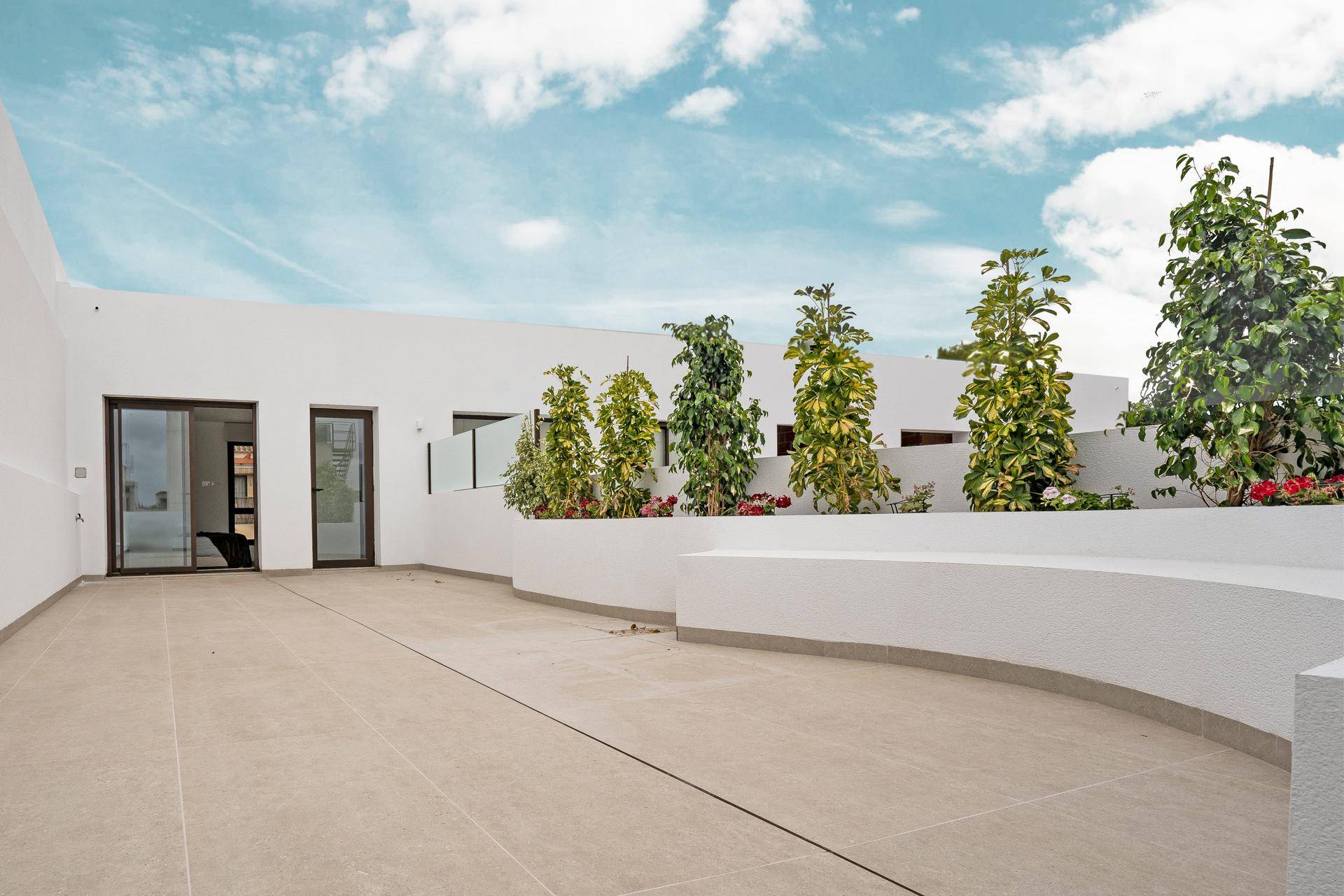 Geräumige Dachterrasse mit Pflanzen und Sitzgelegenheiten, bietet einen idealen Ort zur Entspannung im Freien.