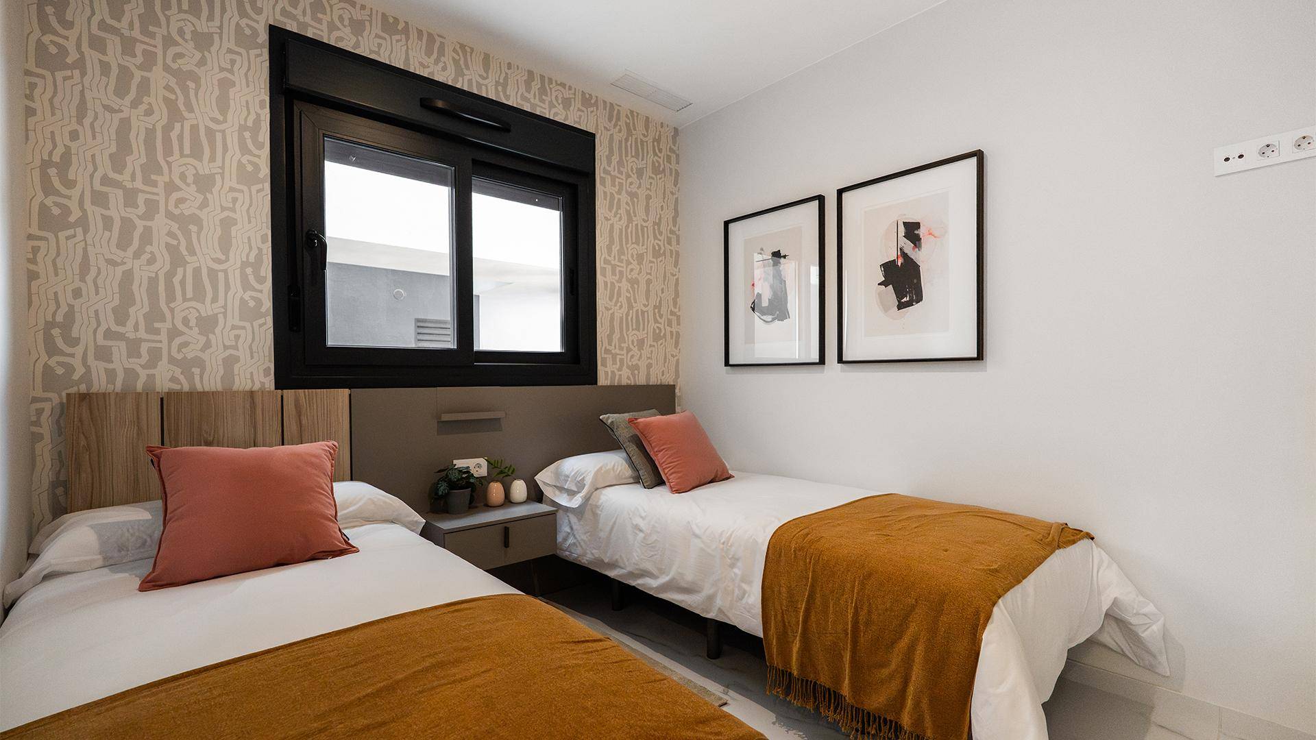 Helles Schlafzimmer mit zwei Einzelbetten, modernem Dekor und einem Fenster.
