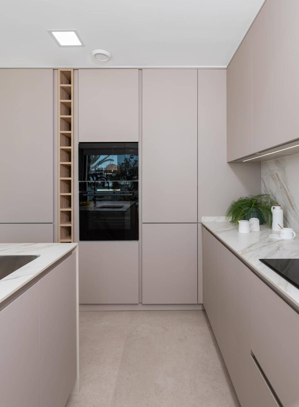 Detailansicht einer modernen Küche mit integriertem Backofen und eleganten Schränken.