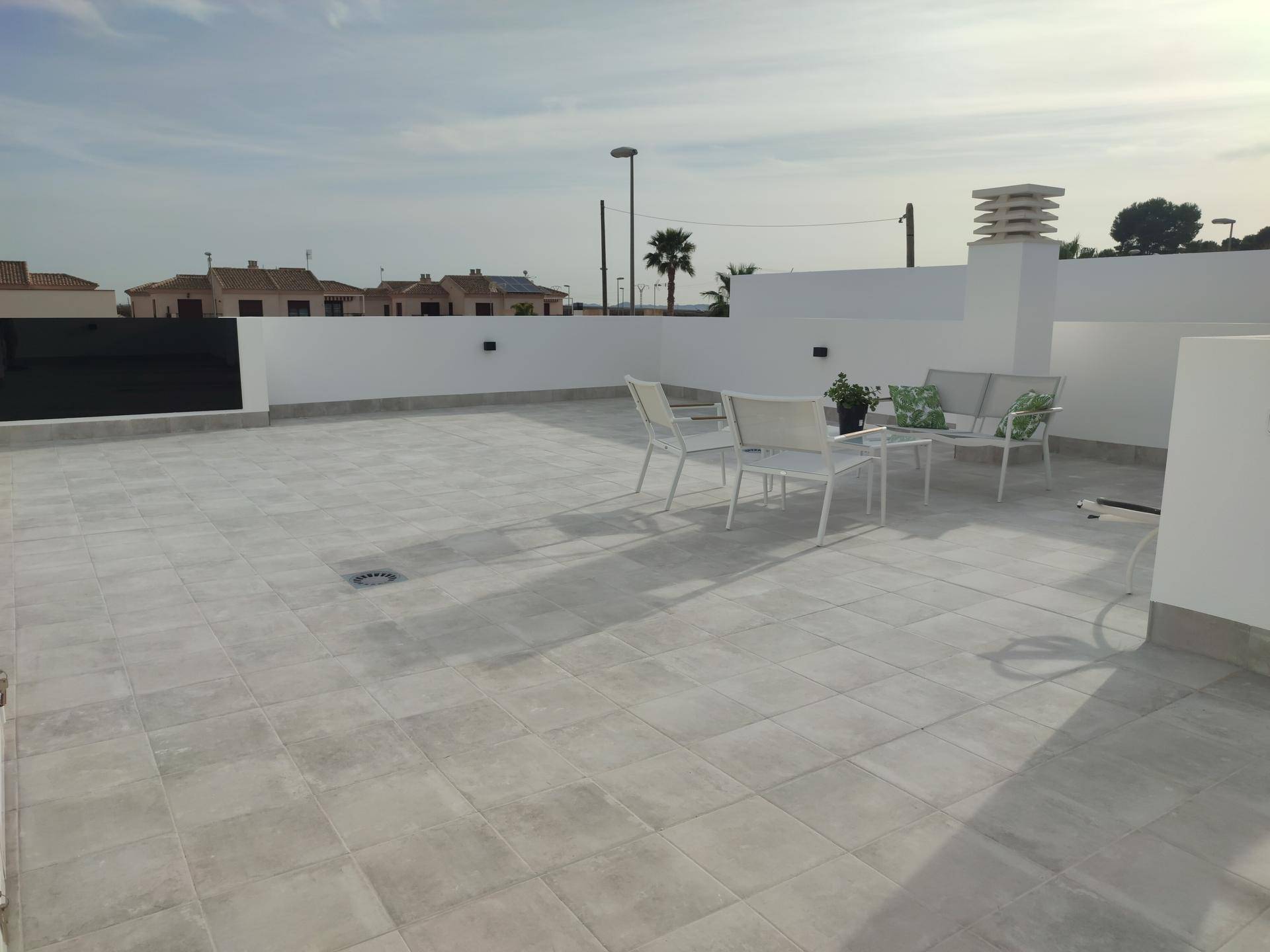 Geräumige Dachterrasse mit Fliesenboden und Gartenmöbeln, ideal für Entspannung im Freien.