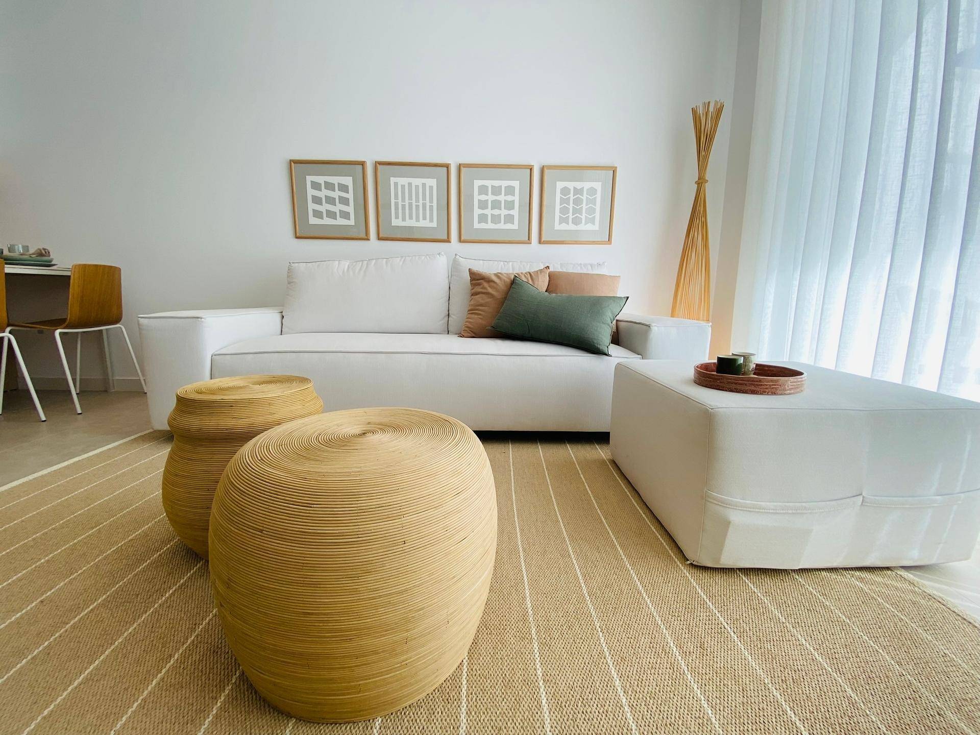 Gemütliches Wohnzimmer mit weißem Sofa, Naturmaterialien und heller Einrichtung.