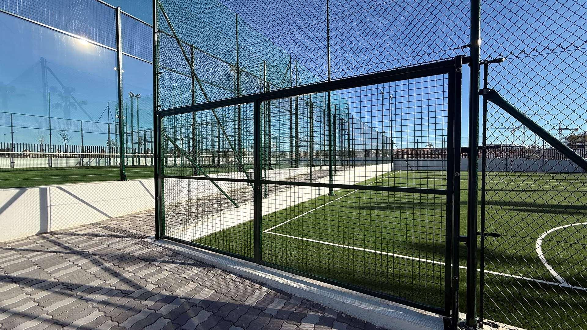 Padel-Tennisplatz mit Kunstrasen und hoher Umzäunung, bereit für sportliche Aktivitäten.