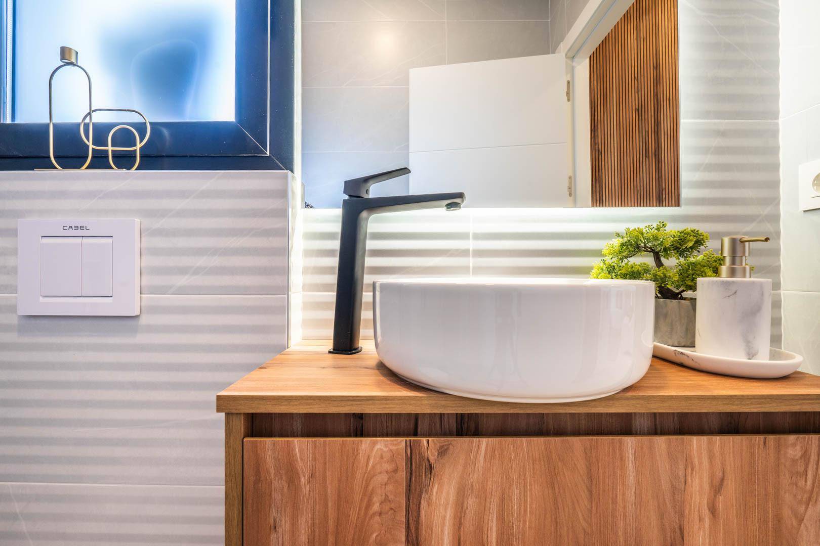 Modernes Badezimmer mit Aufsatzwaschbecken und Holzunterschrank.