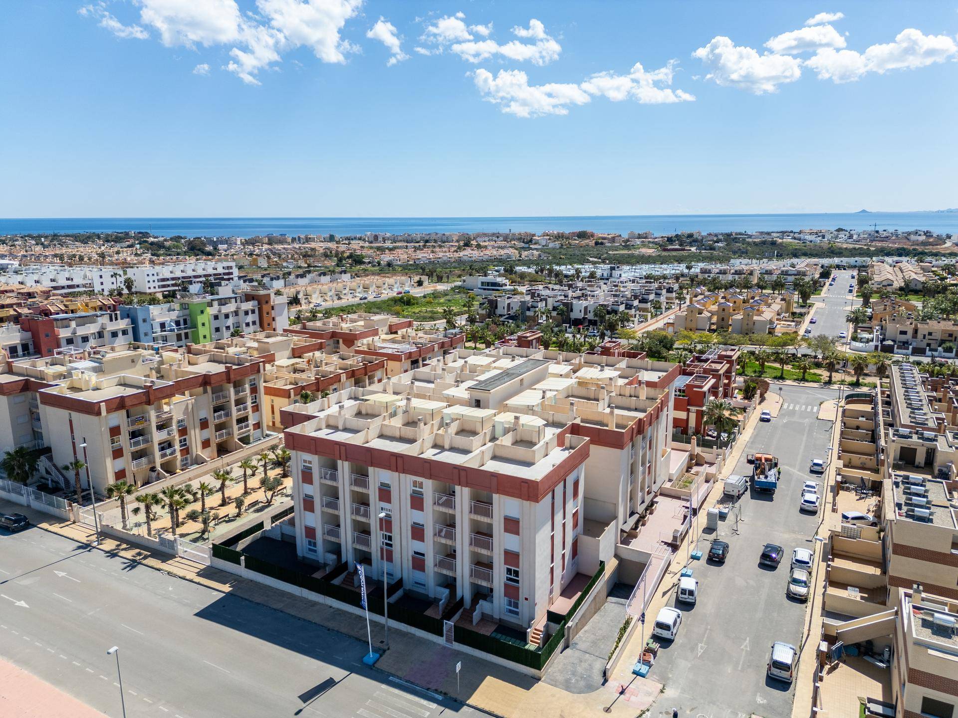 Weitwinkelaufnahme des Wohnkomplexes und der Umgebung mit dem Mittelmeer am Horizont.