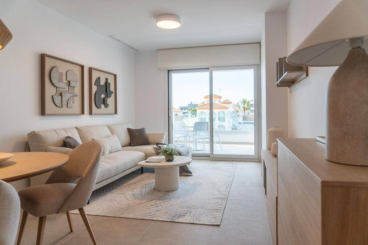 Heller Wohn-Essbereich mit modernem Sofa, Esstisch und direktem Zugang zum Balkon.