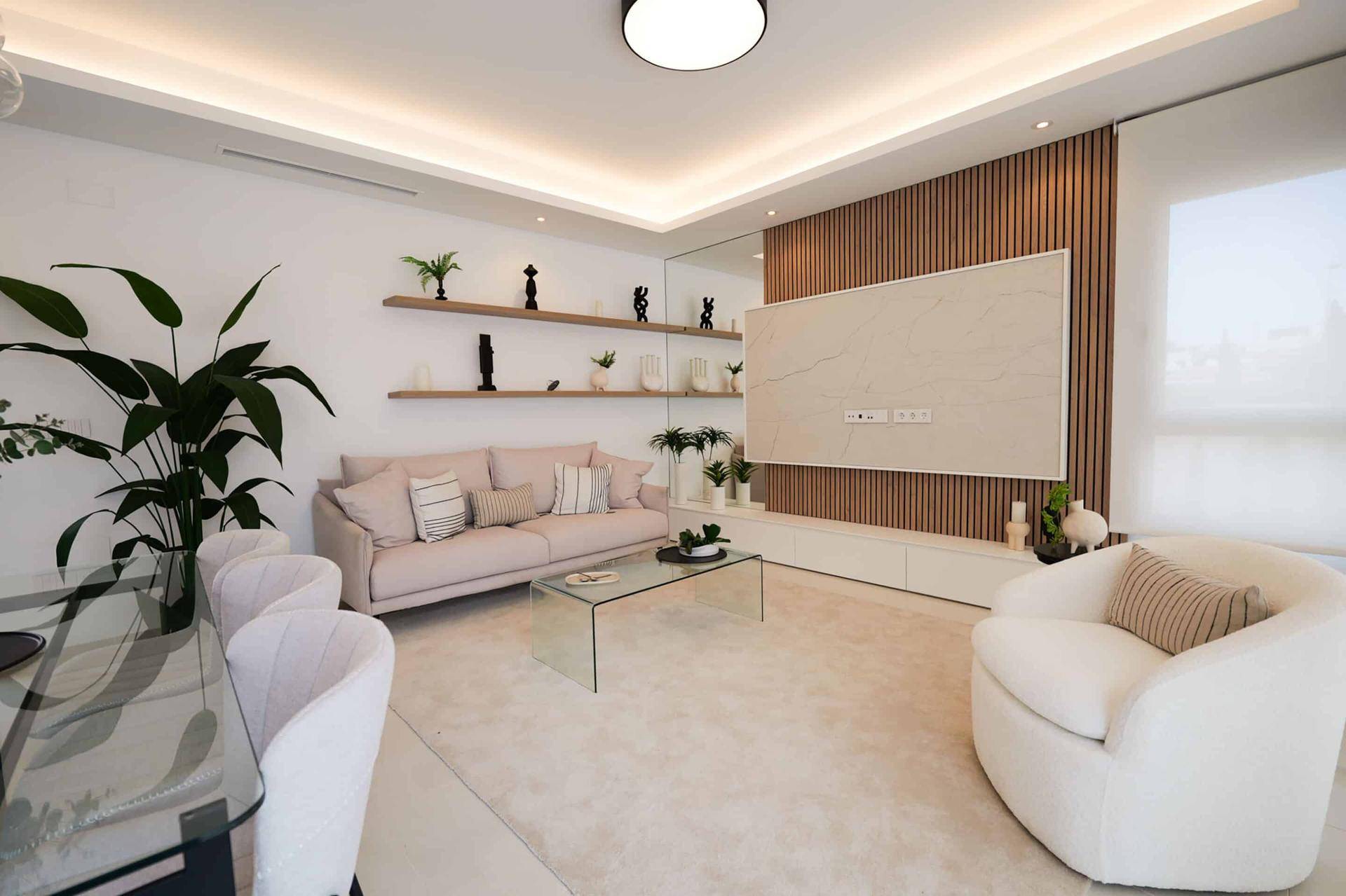 Heller Wohnbereich mit beigem Sofa, Holzwand und gemütlichem Sessel.