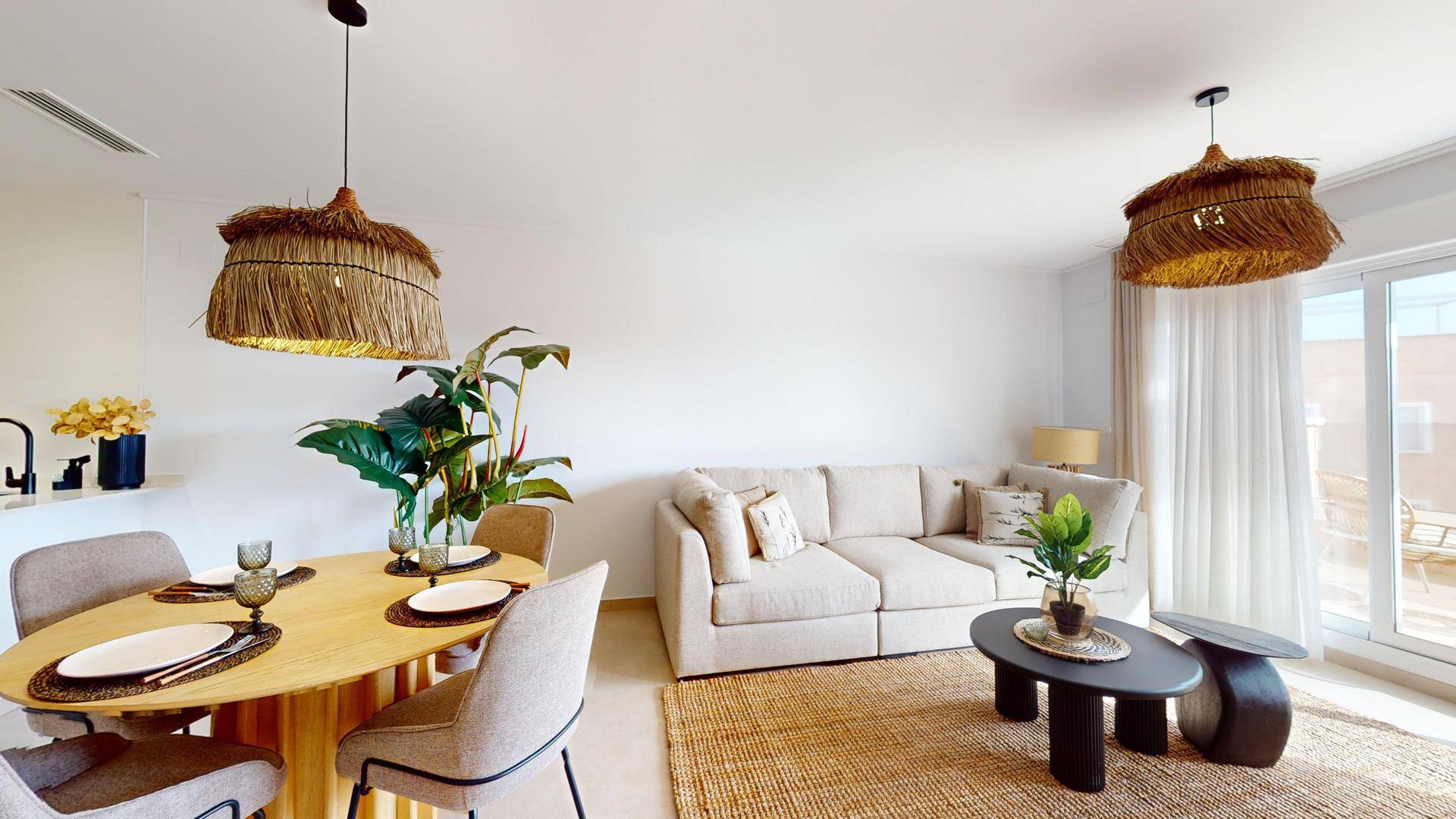 Heller Wohn- und Essbereich mit beigem Sofa, Couchtisch und natürlicher Dekoration.