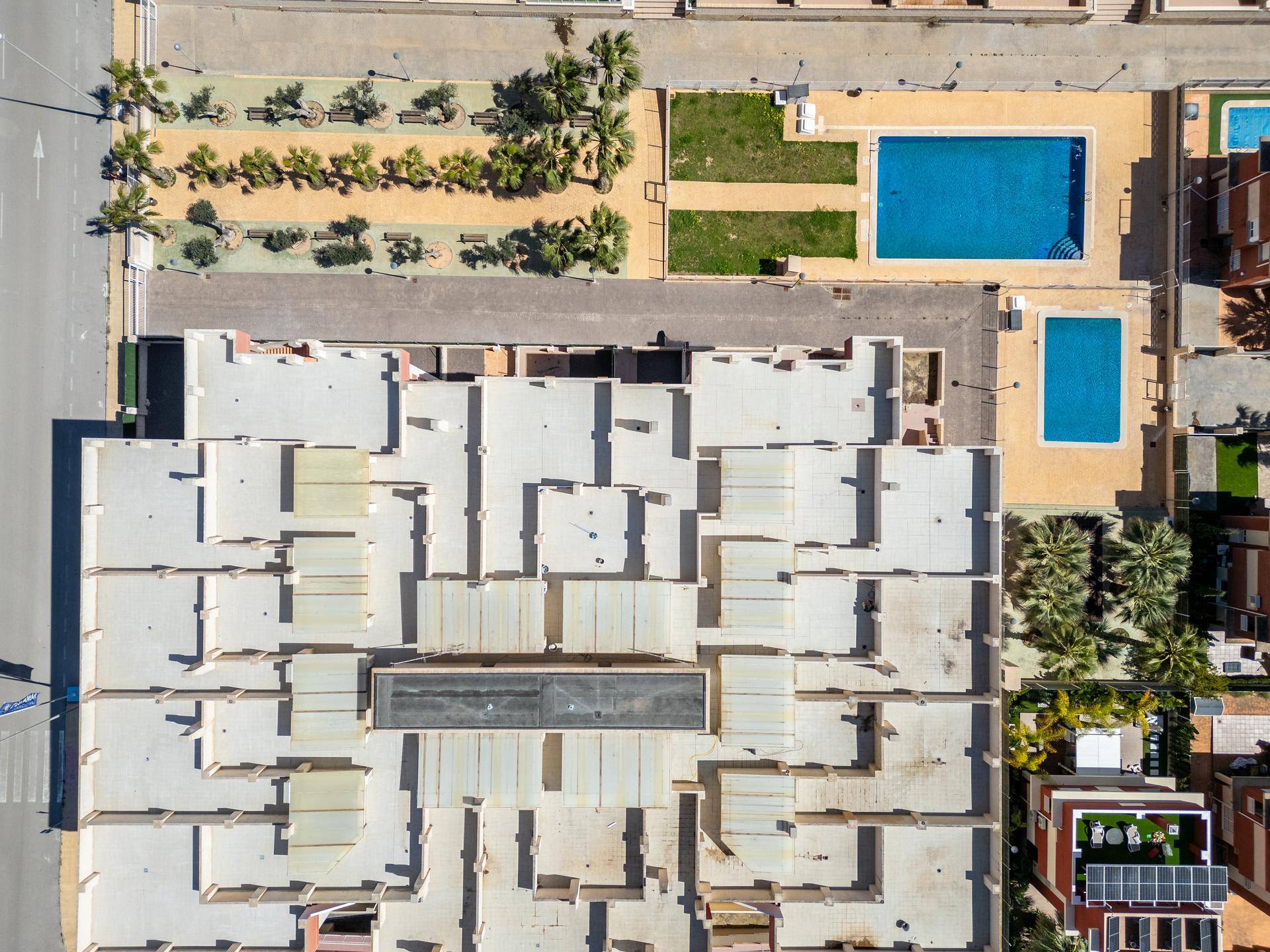 Übersicht aus der Vogelperspektive des Wohnkomplexes mit Pools und angrenzenden Straßen.