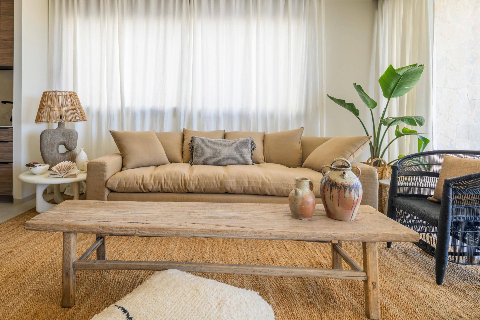 Modernes Wohnzimmer mit gemütlichem Sofa, eleganten Sesseln und großen Fenstern mit Zugang zur Terrasse und Weitblick.
