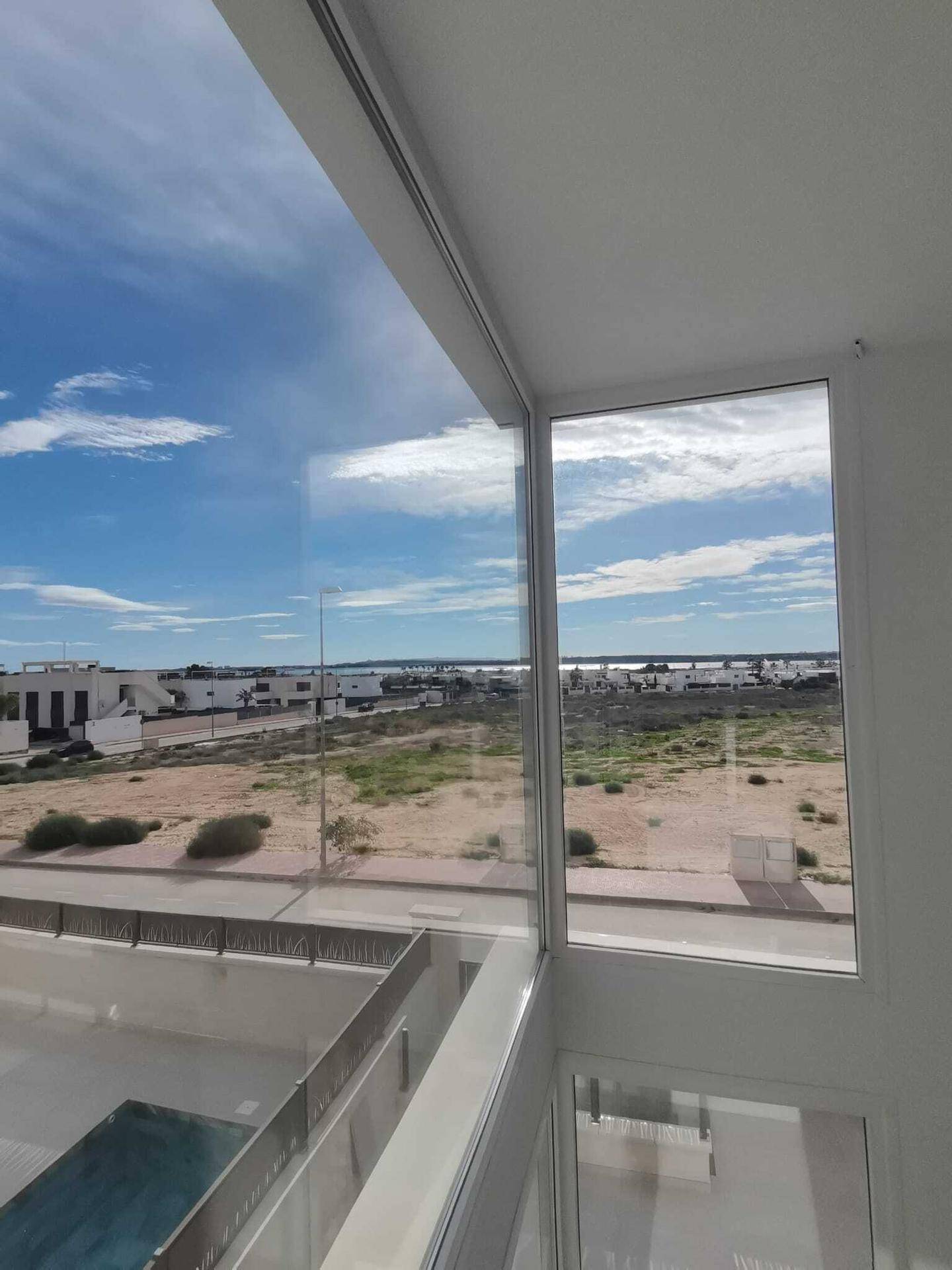 Panoramablick durch große Fenster auf die Umgebung und das Meer, der den Raum mit Licht erfüllt.