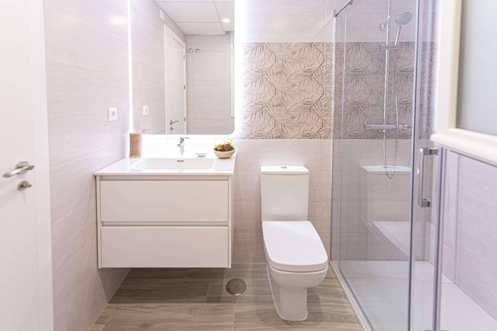 Modernes Badezimmer mit begehbarer Dusche, Waschtisch und stilvollen Fliesen.