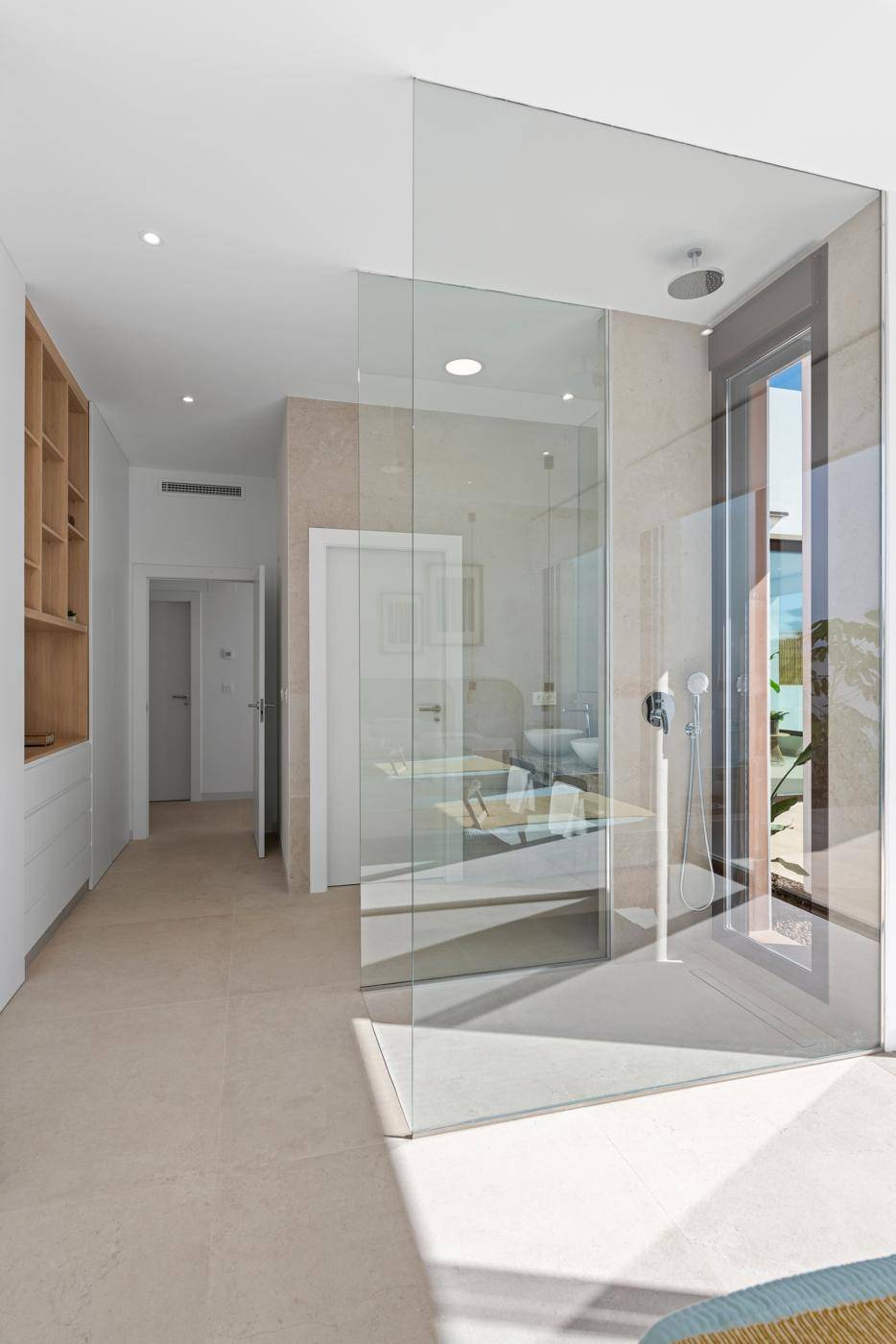 Schlafzimmer mit integrierter, begehbarer Glasdusche und modernem Design.