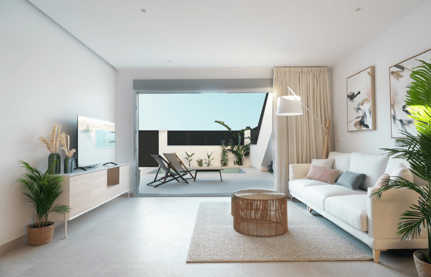 Helles Wohnzimmer mit bequemer Couch, modernen Möbeln und Zugang zur Terrasse.