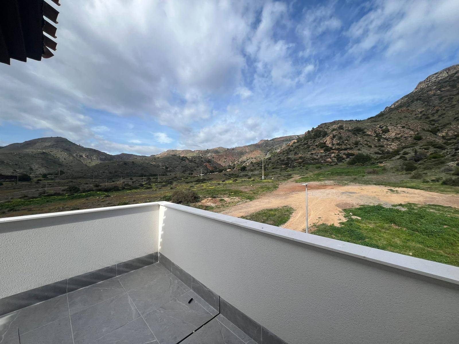 Balkon mit Blick auf die unberührte Natur und die bergige Landschaft unter blauem Himmel.