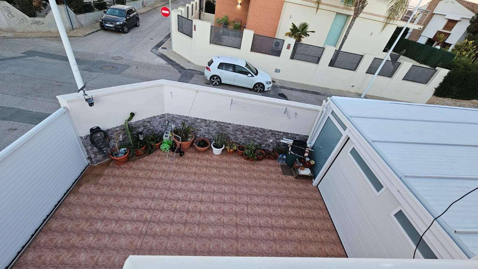 Geflieste Terrasse mit verschiedenen Topfpflanzen und Blick auf die umliegende Nachbarschaft.
