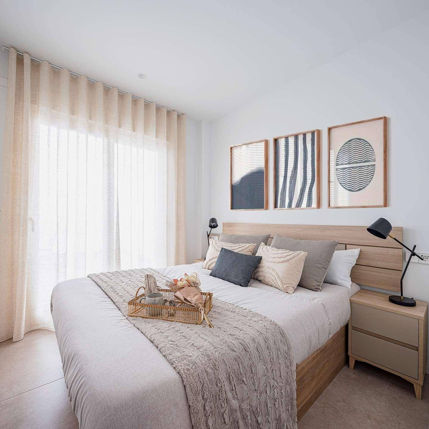 Gemütliches Schlafzimmer mit großem Bett, Holzkopfteil und viel natürlichem Licht durch das Fenster.