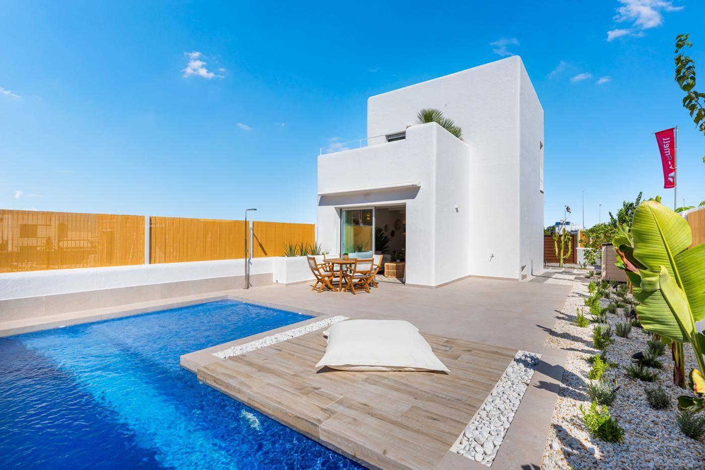 Helle Villa mit privatem Poolbereich und einladender Terrasse unter blauem Himmel.