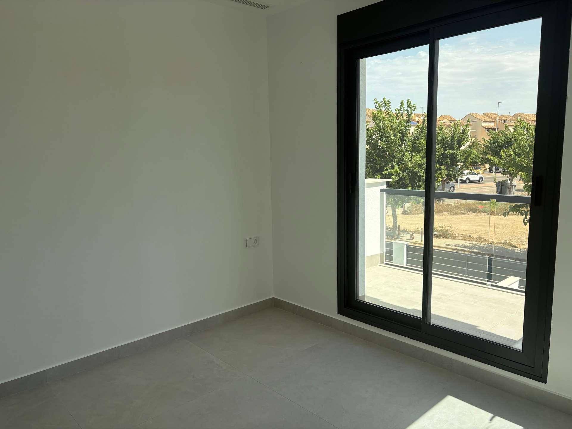 Helles Zimmer mit großem Fenster und Blick auf die Umgebung, ideal als Schlafzimmer.