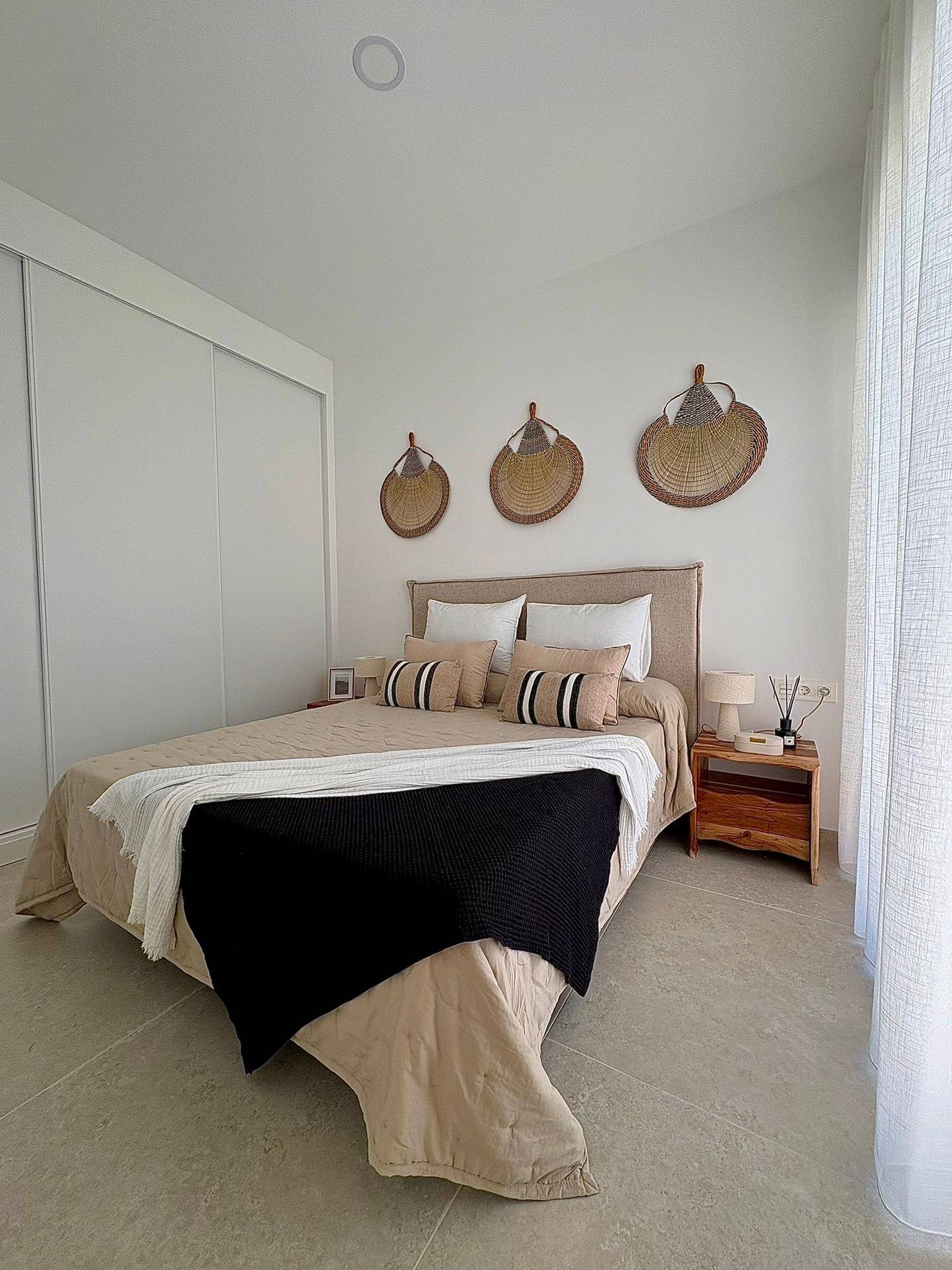 Ruhiges Schlafzimmer mit Doppelbett, Einbauschrank und dekorativen Wandelementen, hell und einladend.