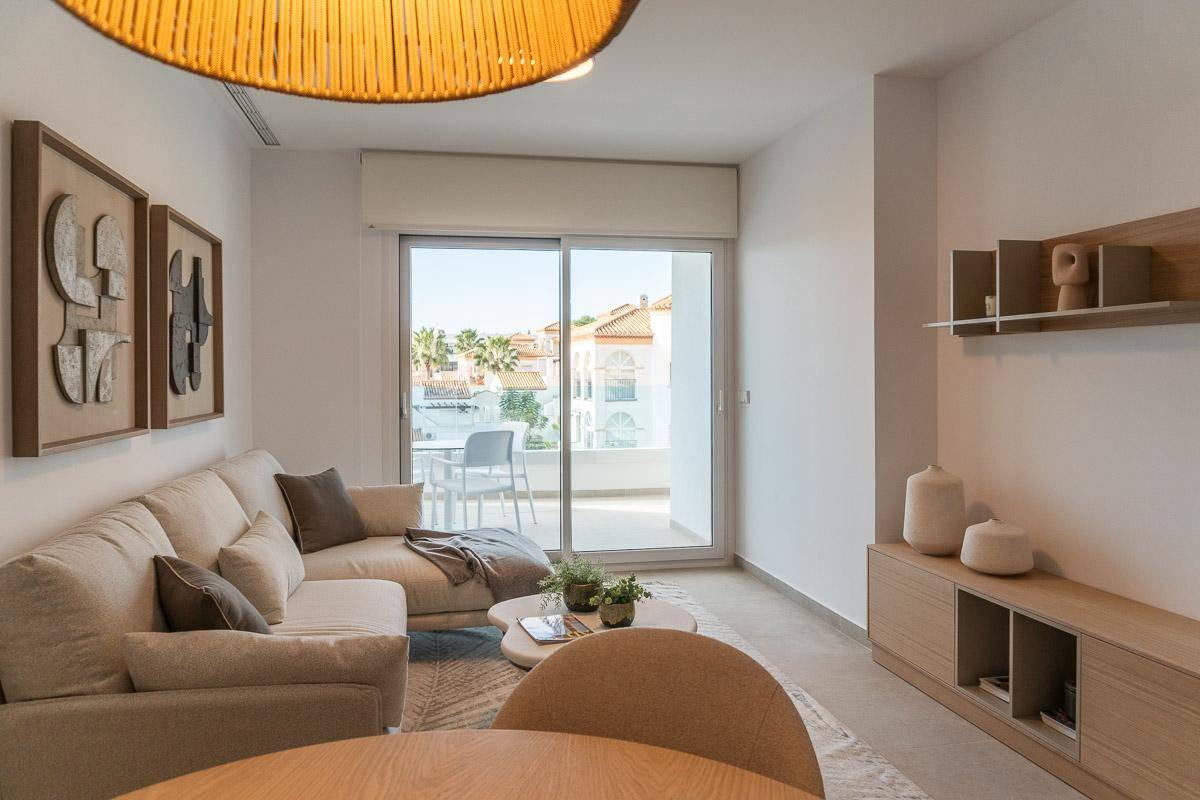 Lichtdurchfluteter Wohn-Essbereich mit modernem Interieur und Zugang zu einem sonnigen Balkon.