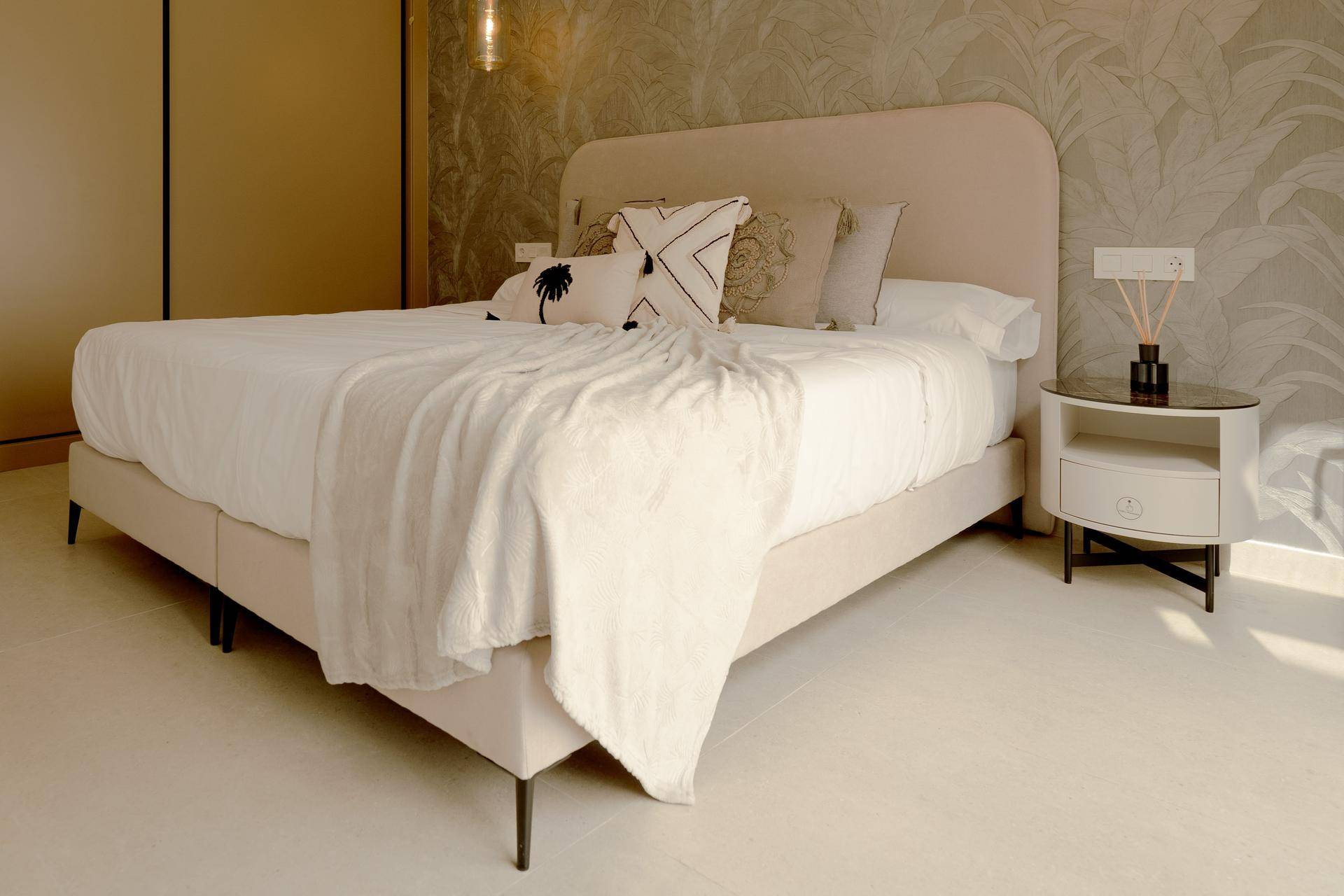 Elegantes Schlafzimmer mit großem Bett, Nachttisch und dekorativer Tapete, schafft eine stilvolle Atmosphäre.
