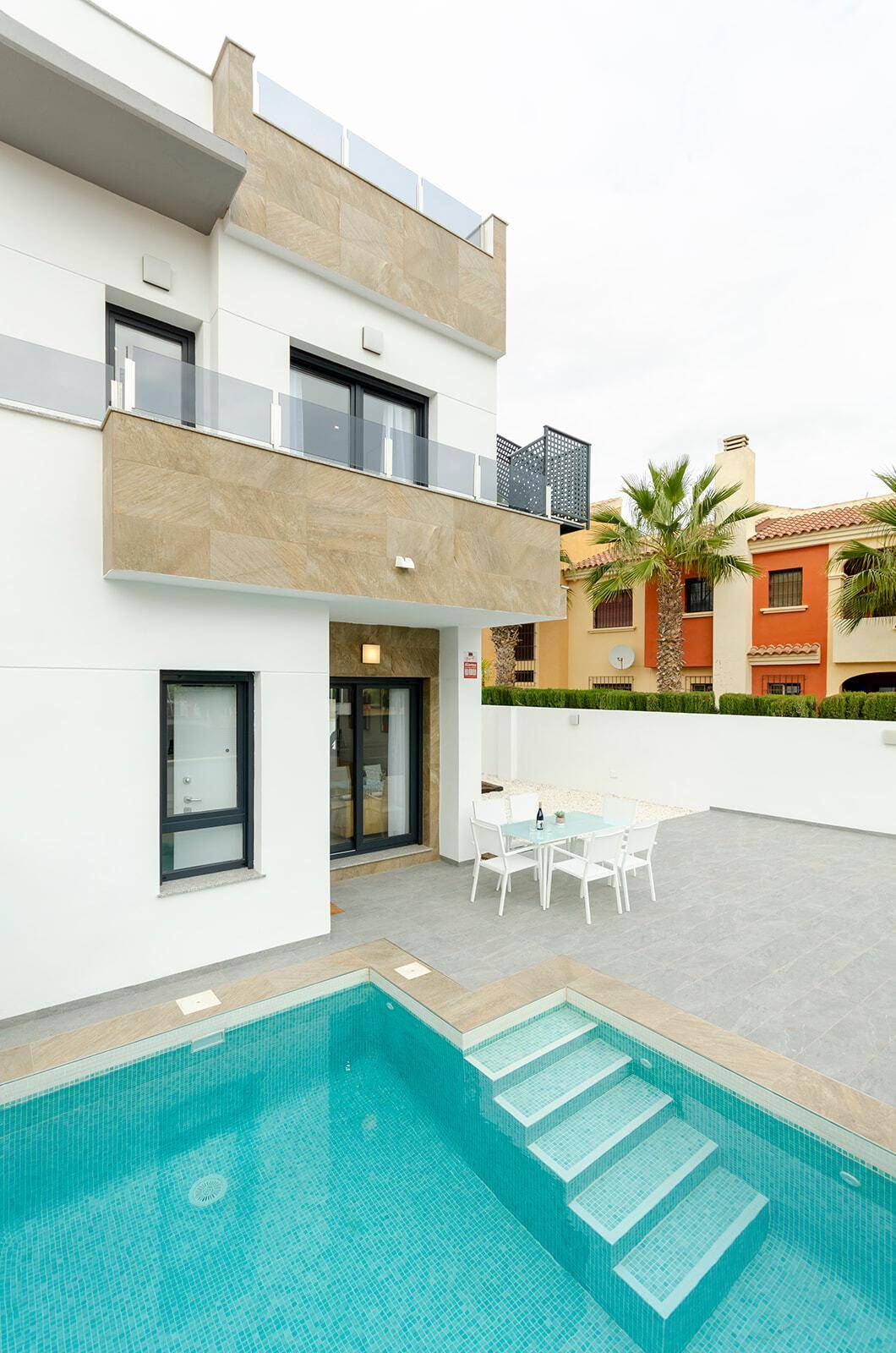 Moderne Villa mit privatem Pool und einladendem Essbereich im Freien.
