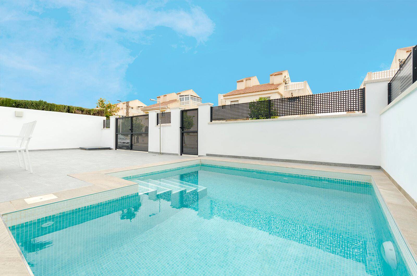 Privater Poolbereich mit blauen Mosaikfliesen und Blick auf die Nachbarschaft.
