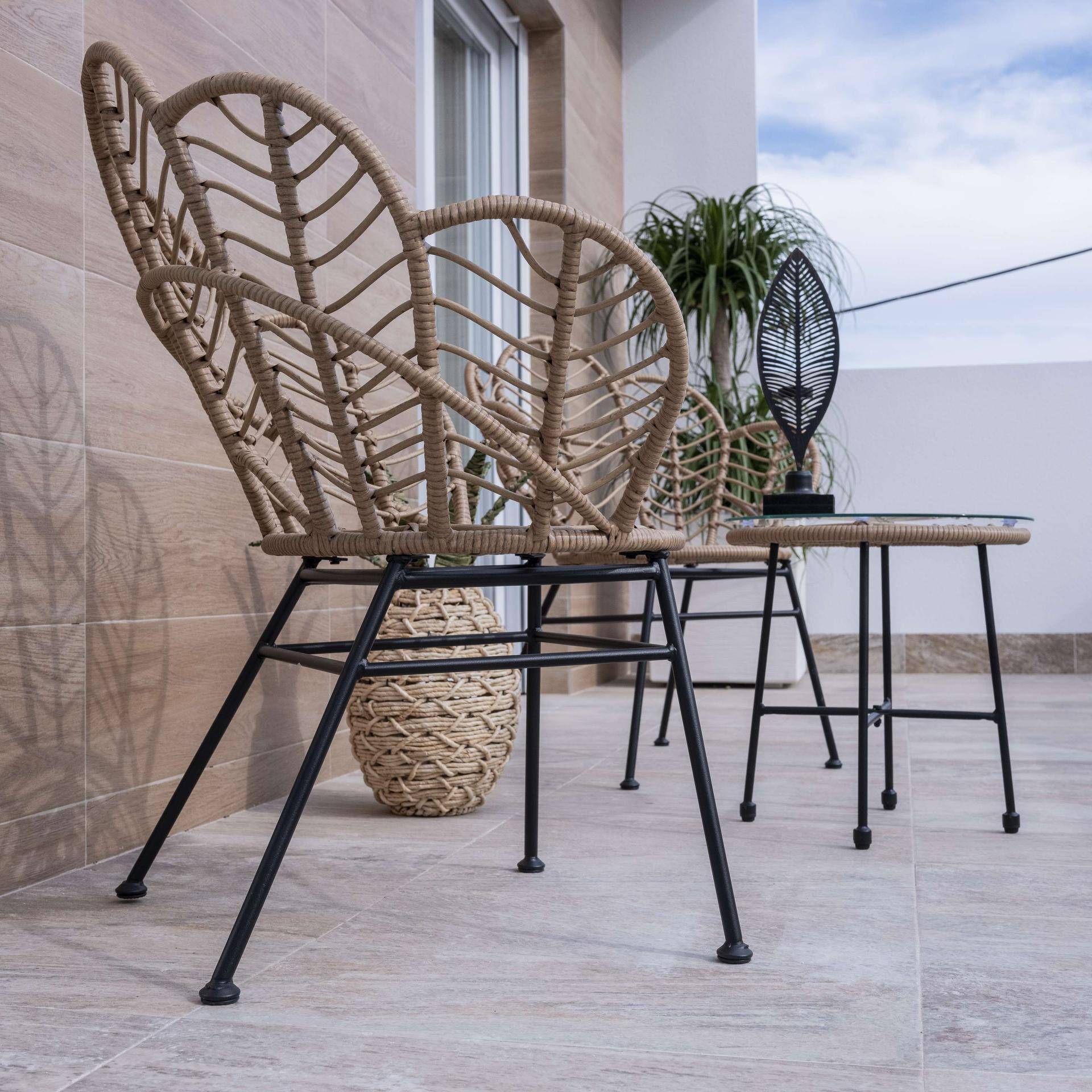 Moderne Korbstühle auf der gefliesten Terrasse, ideal für entspannte Stunden im Freien.