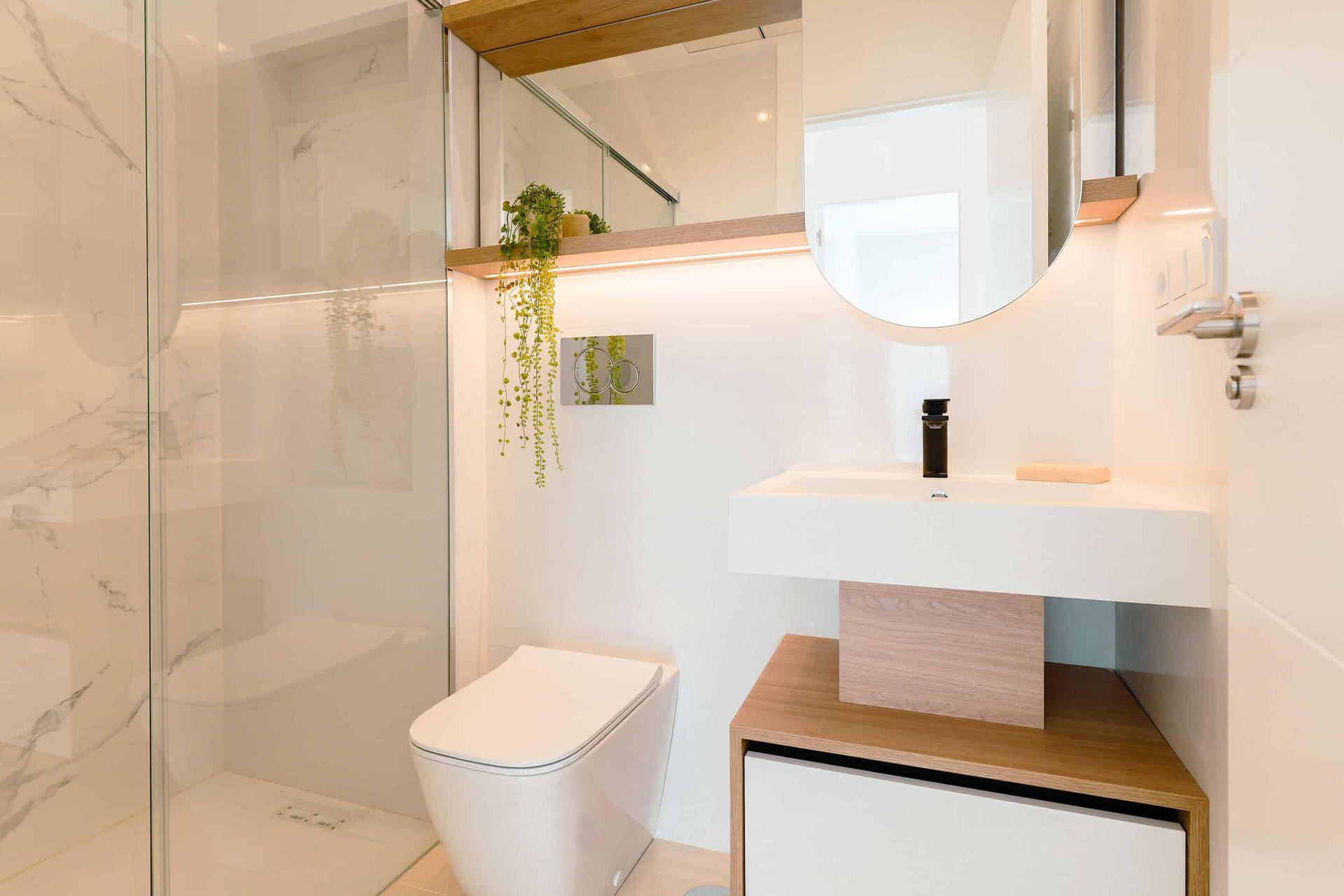 Modernes Badezimmer mit begehbarer Dusche, wandhängendem WC und eleganten Marmorfliesen.