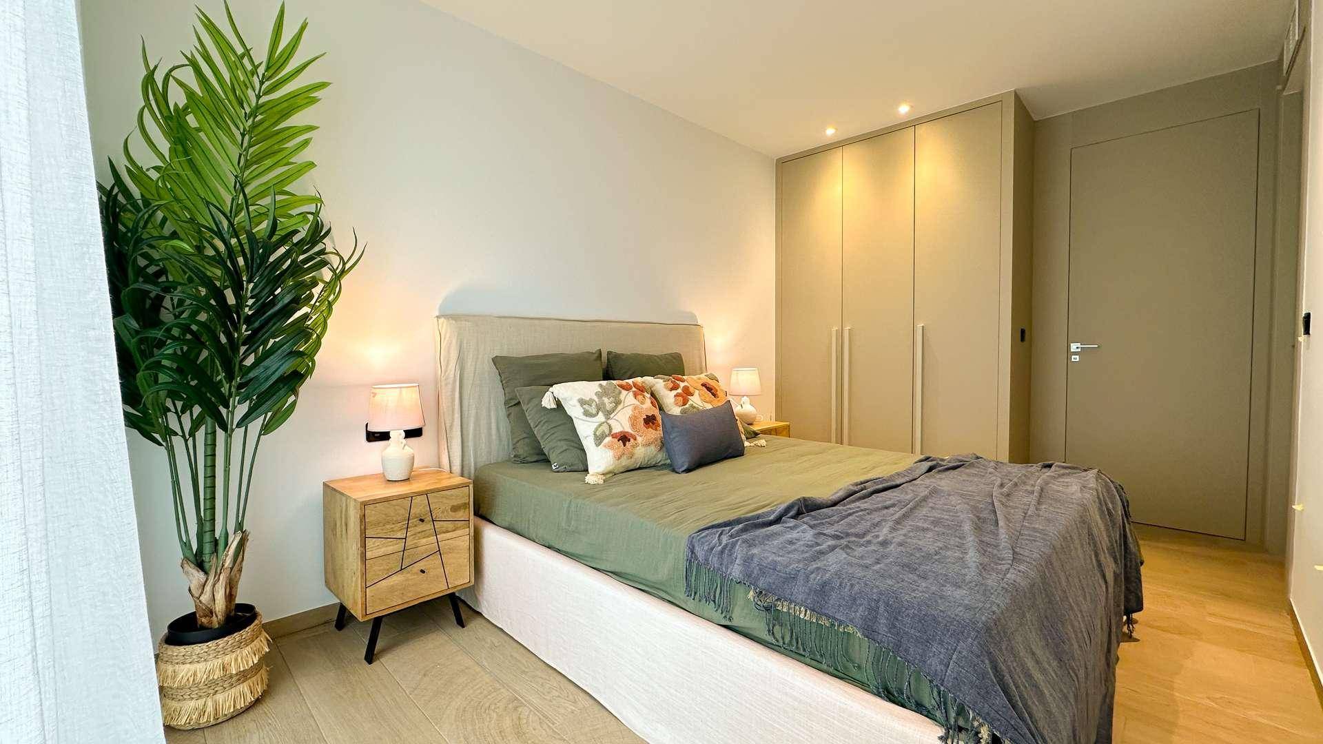 Gemütliches Schlafzimmer mit Doppelbett, Nachttisch und großem Kleiderschrank.