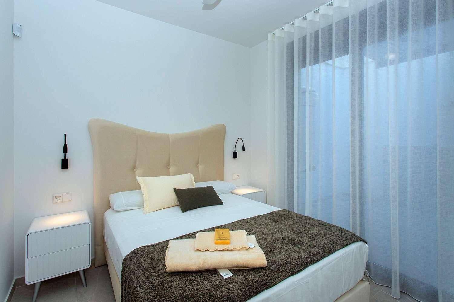 Gemütliches Schlafzimmer mit Doppelbett, Nachttischen und Vorhängen für Privatsphäre und Komfort.