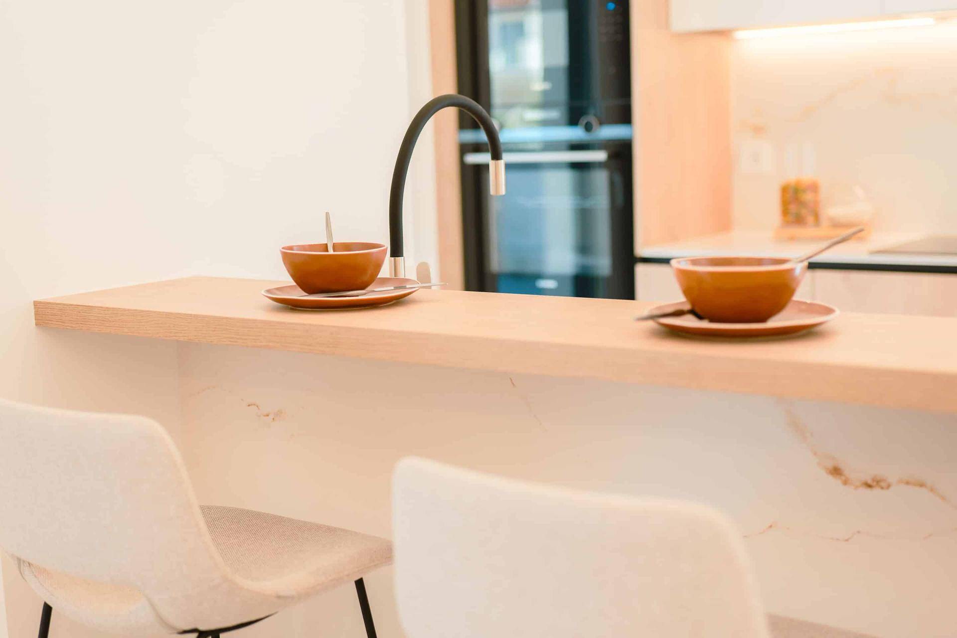Moderne Küchenzeile mit Frühstücksbar und integrierten Geräten, ideal für schnelle Mahlzeiten.